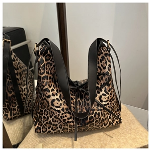 Detail of leopard print tote bag featuring black bow accent and wide shoulder strap