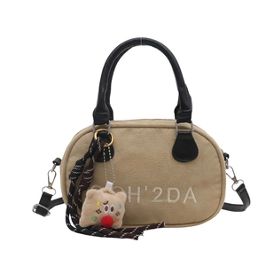 Bowling-Tasche aus Wildlederimitat in Beige mit schwarzen Griffen und Plüschanhänger
