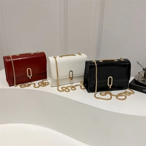 Glossy patent leather crossbody bags in red, white and black with gold buckle