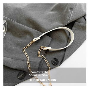 Detail of white leather shoulder strap with gold chain links on a suit jacket