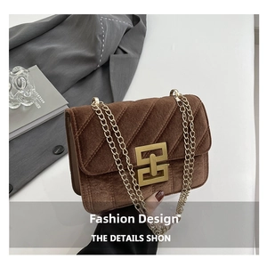 Détail du sac bandoulière en velours marron avec texture matelassée et chaîne