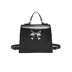 Elegant black leather handbag with a silver metal bow accent and detachable shoulder strap