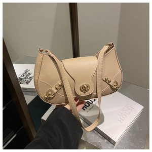 Detail of apricot moon bag featuring golden rivets and metal twist lock closure