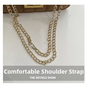 Détail d'un sac en daim marron avec une bandoulière chaîne dorée et fermoir métal