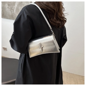 Dettaglio della borsa sottobraccio argento metallizzato con stella e design curvo