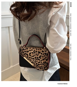 Detailed back view of model wearing the leopard print flap crossbody bag with gold chain