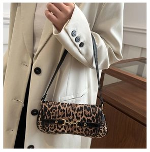 Detail of leopard print shoulder bag with gold horsebit buckle on cream blazer
