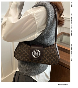 Detail view of vintage monogram baguette bag with silver M-logo buckle on model