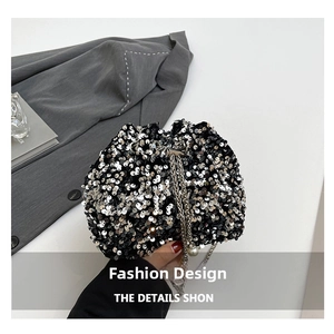 Detail of silver sequin bucket bag with metal chain strap and large pearl accent