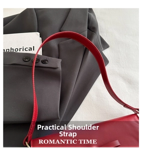 Close-up of the adjustable red leather shoulder strap with neat stitching on baguette bag