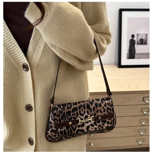 Detail of leopard print shoulder bag featuring a classic gold horsebit metal hardware
