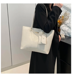 Close-up of cream pebble leather tote bag with gold hardware and small coin purse