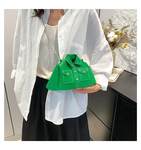 Detail of green jacket-shaped crossbody bag with silver chain and white stitching