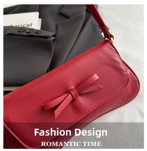 Detail of red leather bag featuring a chic leather bow and metallic clasp connector