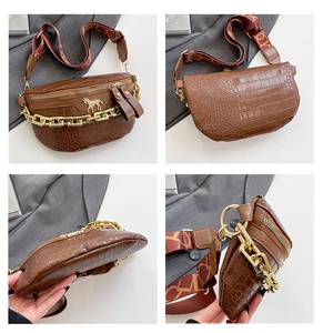 Detailansichten der braunen Krokodil-Brusttasche mit Goldpferd-Tag und breitem Gurt
