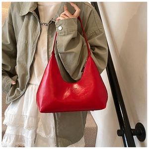 Fashionable red hobo bag with glossy finish and silver zipper shown in street style