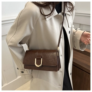 Dettaglio della borsa a tracolla in pelle vintage marrone scuro con fibbia a ferro di cavallo