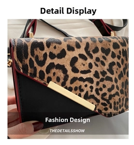 Detail of leopard print and black leather stitching with gold metal hardware buckle