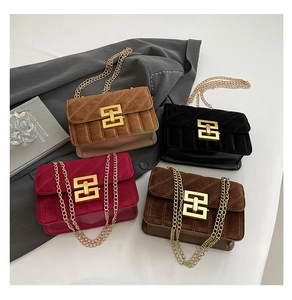 Détail de quatre sacs en velours avec surpiqûres et boucles géométriques dorées