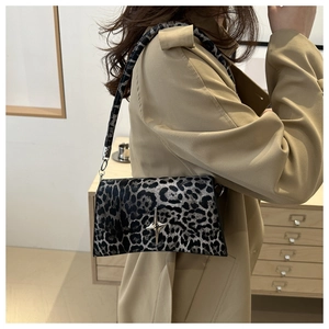 Dettaglio borsa leopardata con fibbia a stella d'argento su un trench coat beige