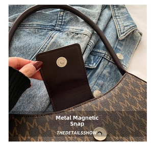 Detailed macro view of the silver magnetic snap closure and smooth brown leather interior