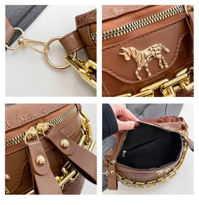 Details einer Krokodilmuster-Ledertasche mit goldenem Pferde-Emblem und Doppelreißverschluss
