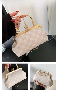 Detail view of retro white shell bag featuring clover texture and gold clasp