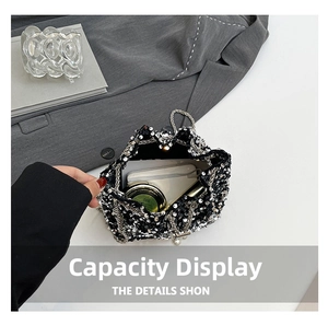 Internal capacity of sequined bucket bag showing smartphone, powder and lipstick