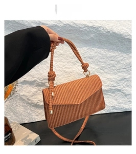 Detail of dark brown woven shoulder bag with unique knotted handle and slim strap