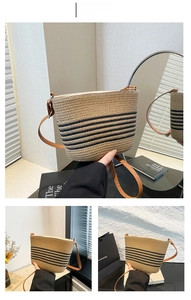 Close-up of the beige straw bucket bag with black stripes and brown leather strap details
