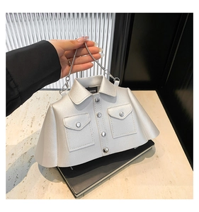 Detail of silver jacket-shaped bag with metal chain strap and button accents