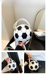 Detail of soccer ball shaped handbag in black and white with metal chain strap