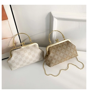 Detail of vintage shell bags in beige and brown with clover patterns and metal chain