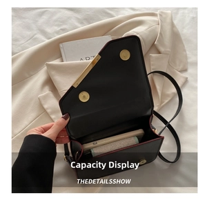 Interior capacity of black PU leather shoulder bag with red edges and golden hardware