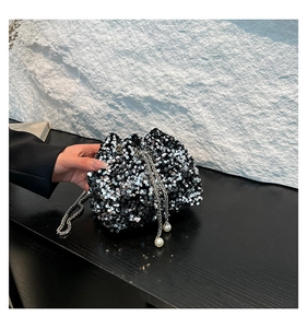 Detail of sequined bucket bag with silver chain strap and large pearl drop accents