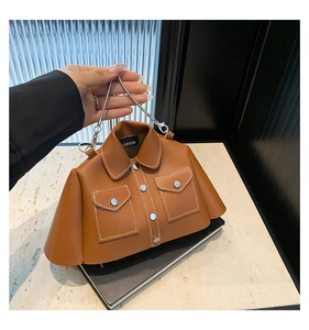 Detail of a brown shirt-shaped PU leather bag with white stitching and metal chain