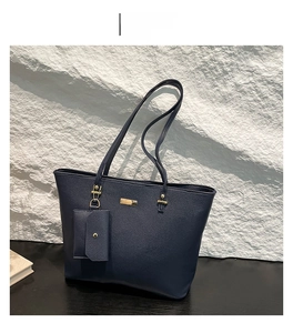 Close-up of blue lychee grain leather tote bag with matching mini pouch and gold hardware
