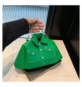 Detail of green shirt-shaped crossbody bag with white stitching and silver chain