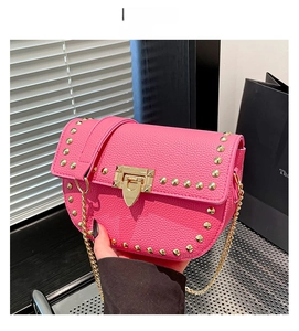 Détail du sac en cuir rose vif avec des rivets dorés et un fermoir métallique chic