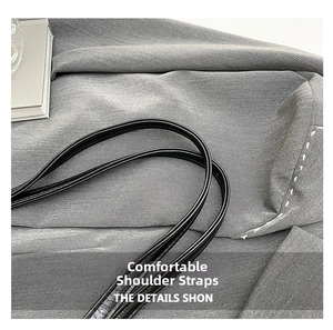 Close-up of dual black leather shoulder straps featuring fine pebble grain texture