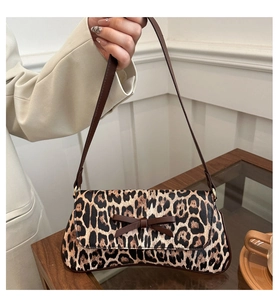Close-up of leopard print baguette bag with a decorative brown bow and slim shoulder strap