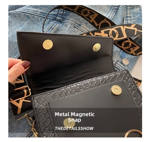 Détails des fermoirs magnétiques dorés et texture tissée sur un sac besace noir