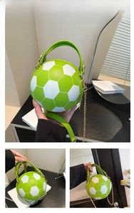 Detail of green and white football-shaped crossbody bag with gold chain and handle