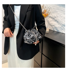 Detail of sparkly sequin bucket bag featuring silver chain strap and pearl charm accent