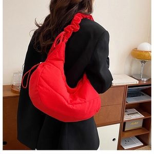 Bolso de hombro rojo plisado con correa con volantes en un ambiente acogedor