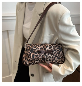Close-up of leopard print underarm bag with brown bow detail and slim shoulder strap