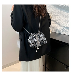 Elegant bucket bag with shimmering sequins and pearl drawstring detail on model