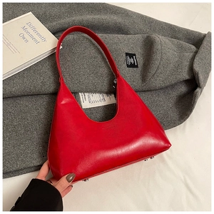 Detail view of red crescent hobo bag featuring glossy finish and protective metal feet