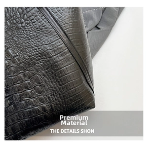Close-up of black crocodile embossed texture on a high-shine vintage tote bag surface