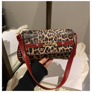 Detail of leopard print handbag featuring gold horsebit buckle and red strap accents
